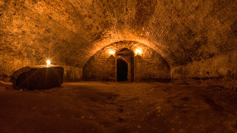 Scottish underground dungeon halls lit only by torchlight