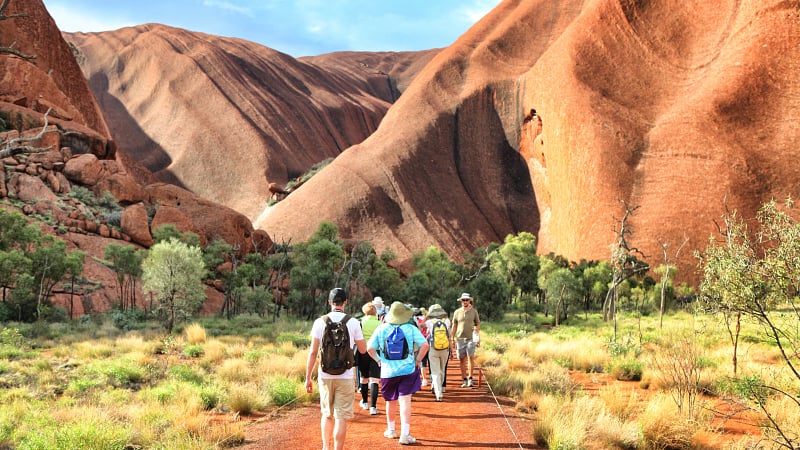 a group of tourists hiking along the famous Valley of the Winds Walk at Kata Tjuṯa (historically also known as The Olgas).