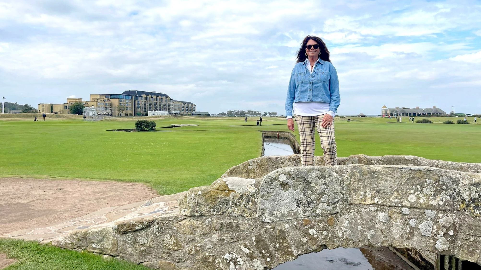 a traveler on the iconic Swilcan Bridge in St Andrews Links