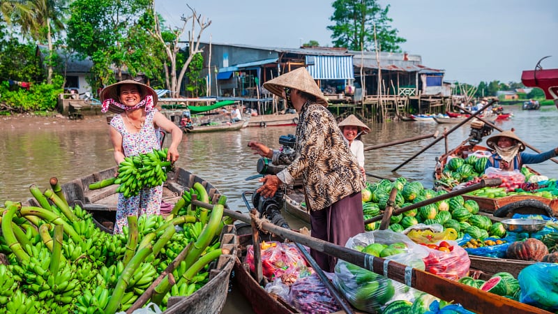 Vietnamese women selling fruits on floating market, Mekong River Delta, Vietnam