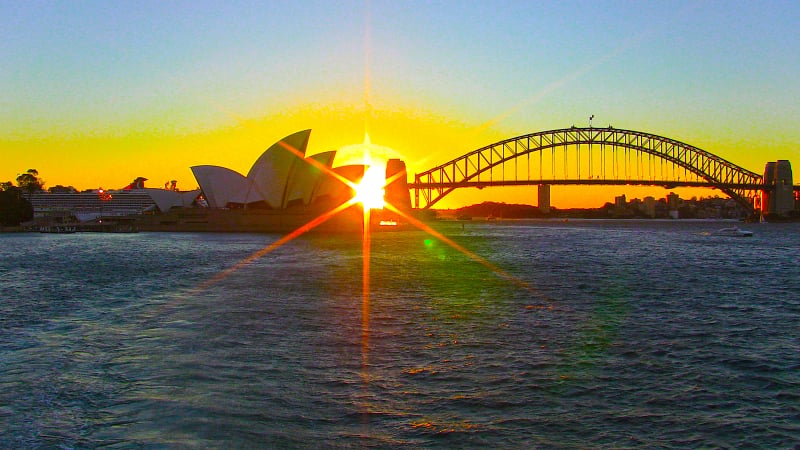 a striking sunset over Sydney Harbour in Australia.