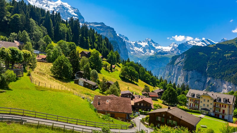 This image captures a scenic view of the alpine village of Wengen looking down into the Lauterbrunnen Valley in the Bernese Oberland region of Switzerland.