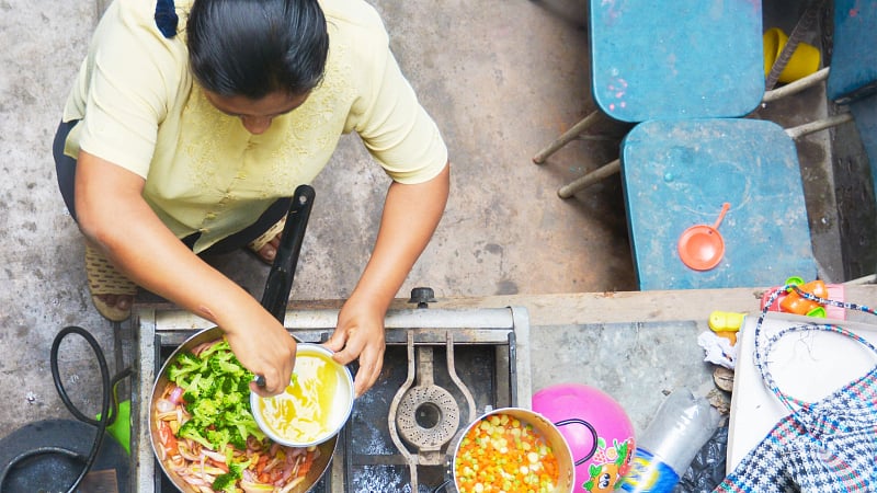 A woman preparing food at a stove showcasing South American cuisine.