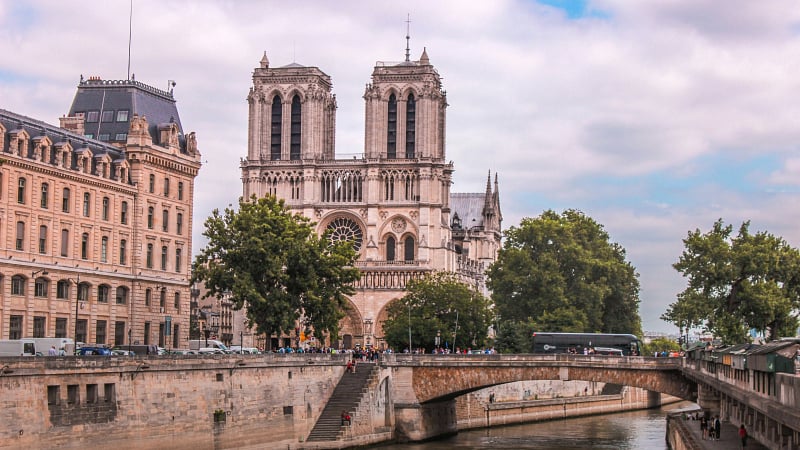 Notre Dame de Paris cathedral and the Pont au Double bridge spanning the Seine River.