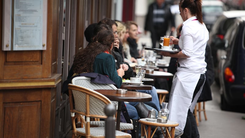 an outdoor seating area of a Parisian-style cafe, commonly found along sidewalks in France