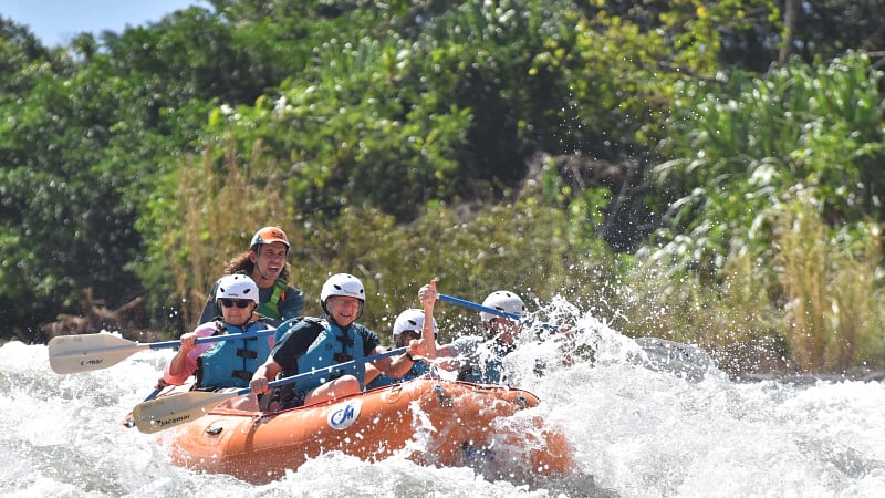 This is a group of people whitewater rafting down a river.