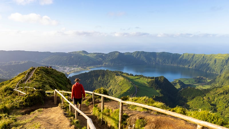 Hiker in a red jacket at the caldera on São Miguel island in the Azores
