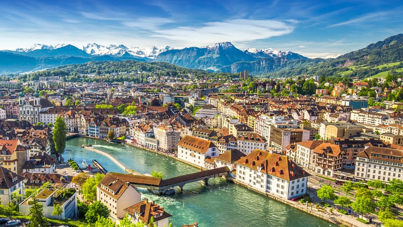 This is a panoramic aerial view of Lucerne (Luzern), Switzerland, showing its historic Old Town along the turquoise Reuss River.
