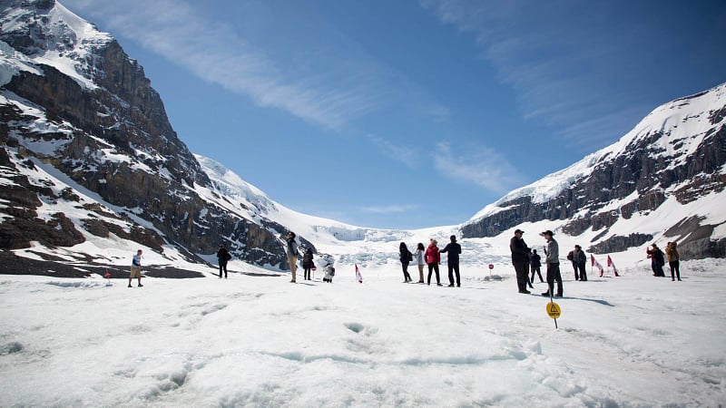 Tourists exploring the Athabasca Glacier, which is located within the Columbia Icefield in Jasper National Park, Alberta, Canada