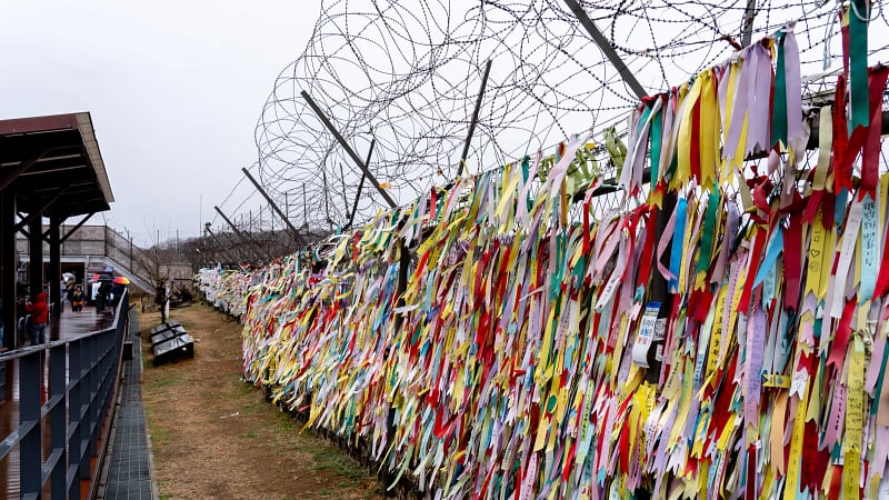 This image shows prayer ribbons tied to a barbed-wire fence at Imjingak Park, located near the Demilitarized Zone (DMZ) in Paju, South Korea
